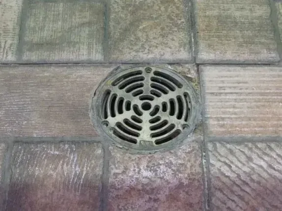 Floor drain grate where sewer backup water first rises into a lower level
