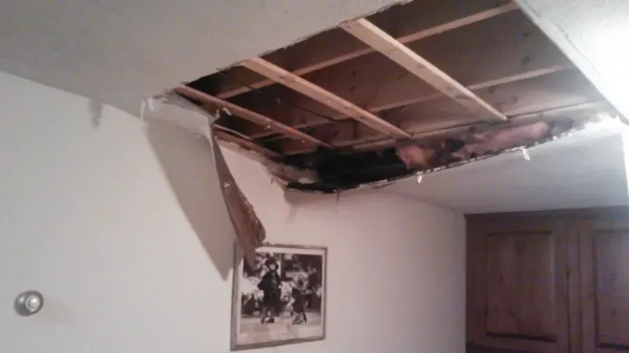 Ceiling drywall removed to dry the joists after water came through from above