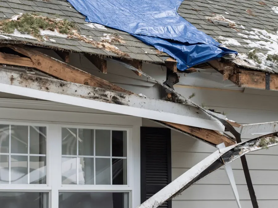 Emergency tarp secured over a section of storm-damaged roof
