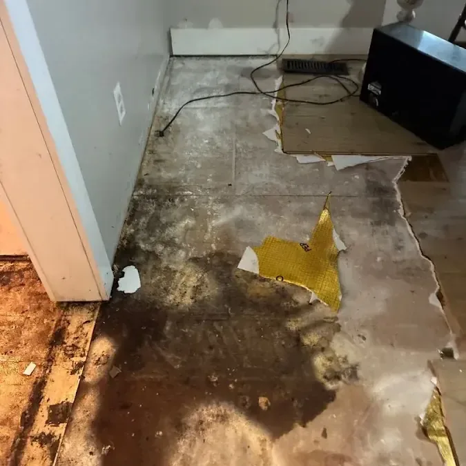 Water from a burst pipe spreading over the floor and along the baseboards
